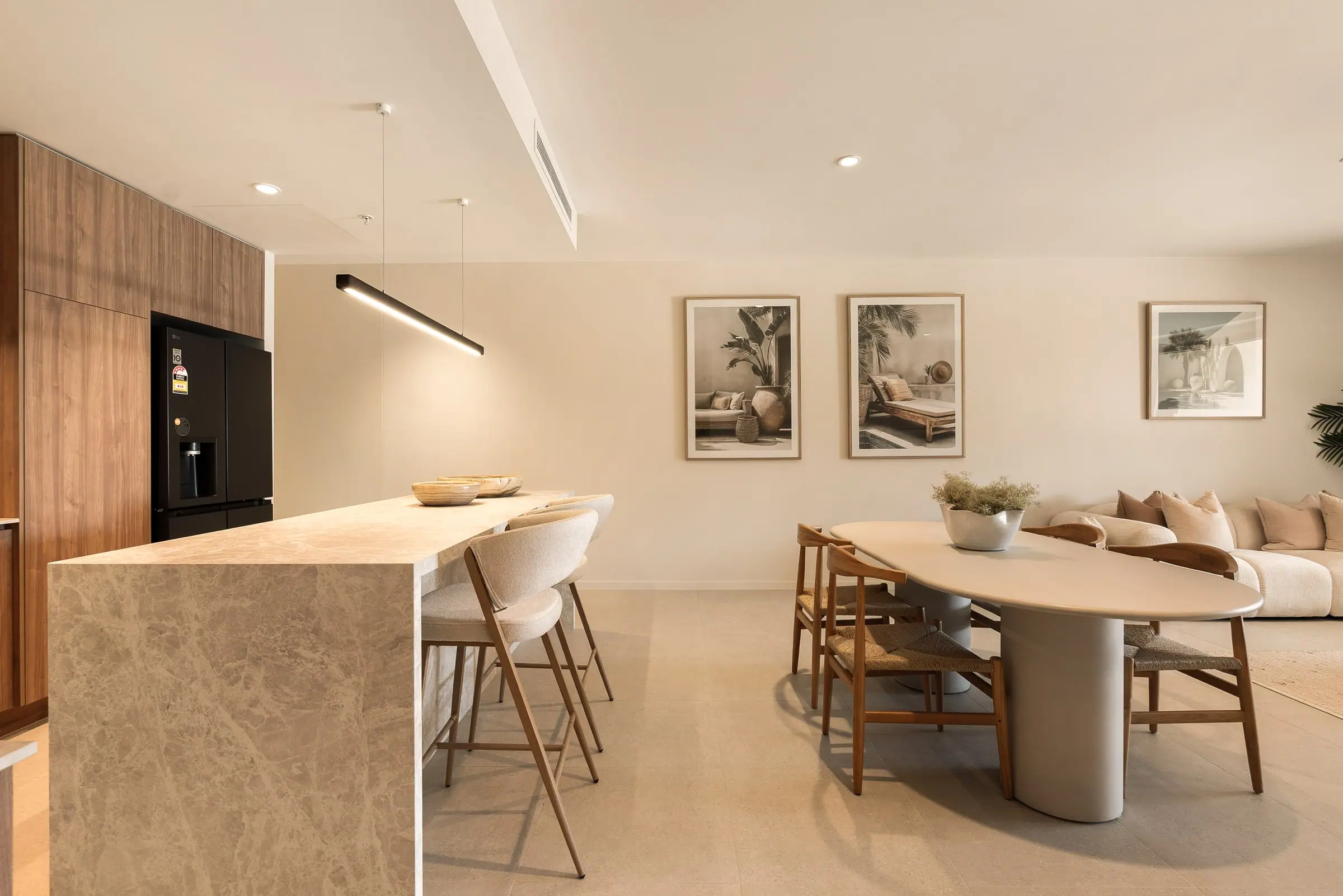 Open-plan kitchen with a stone island, dining and living